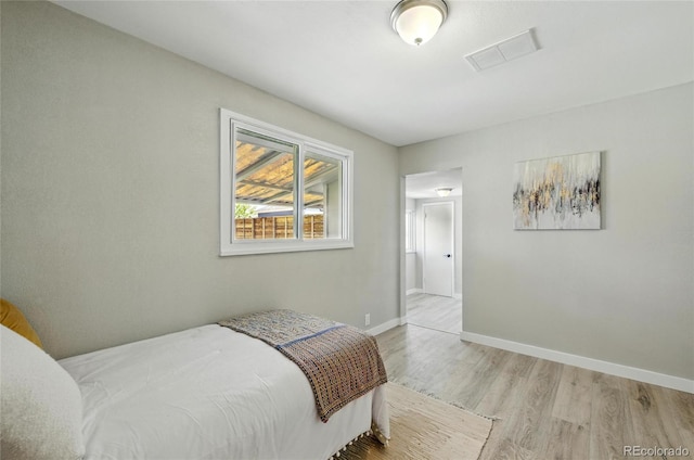 bedroom with wood finished floors and baseboards