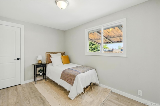 bedroom featuring wood finished floors and baseboards