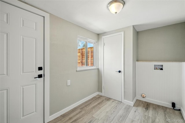 laundry area with washer hookup, light wood-style flooring, baseboards, and a wainscoted wall