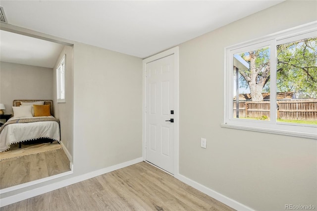 foyer with light wood-style floors, baseboards, and healthy amount of natural light