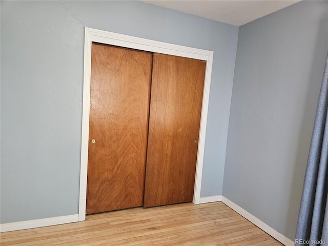 1822 E Pikes Peak Ave, Colorado Springs, CO 80909 - unfurnished bedroom featuring wood finished floors, baseboards, and a closet