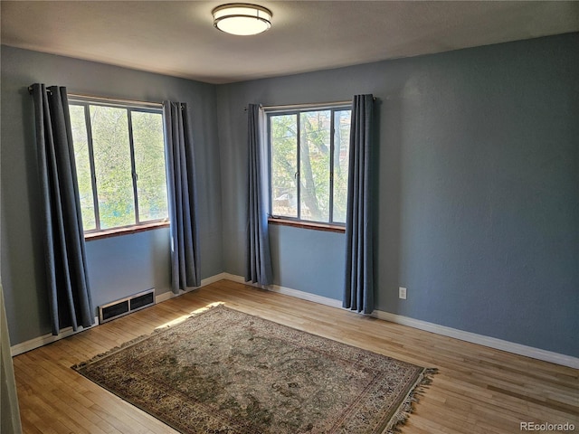 1822 E Pikes Peak Ave, Colorado Springs, CO 80909 - empty room featuring wood finished floors, healthy amount of natural light, and baseboards