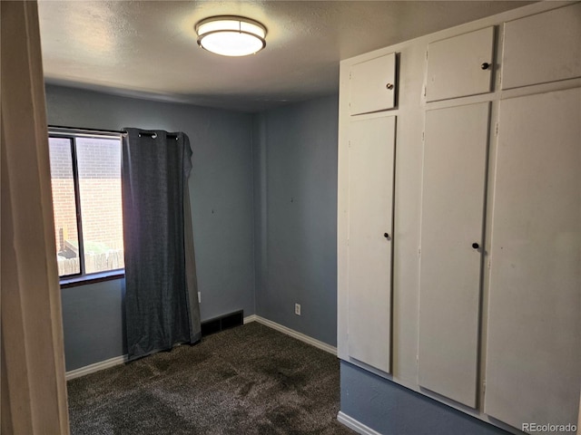 1822 E Pikes Peak Ave, Colorado Springs, CO 80909 - unfurnished bedroom featuring dark carpet and baseboards