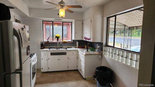 1822 E Pikes Peak Ave, Colorado Springs, CO 80909 - kitchen with a sink, white appliances, light countertops, white cabinetry, and ceiling fan