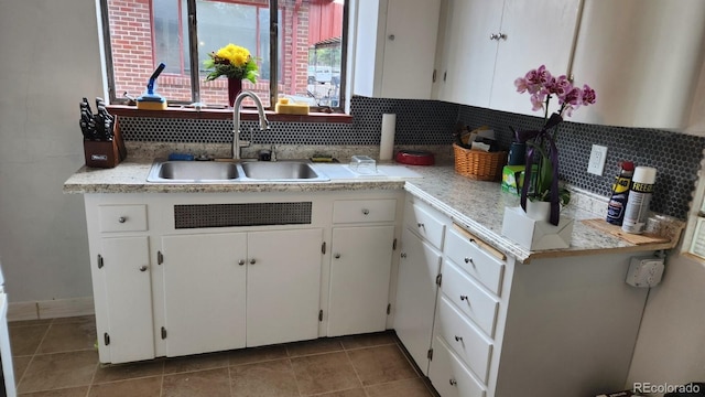 1822 E Pikes Peak Ave, Colorado Springs, CO 80909 - kitchen featuring a sink, tasteful backsplash, white cabinets, light countertops, and tile patterned flooring