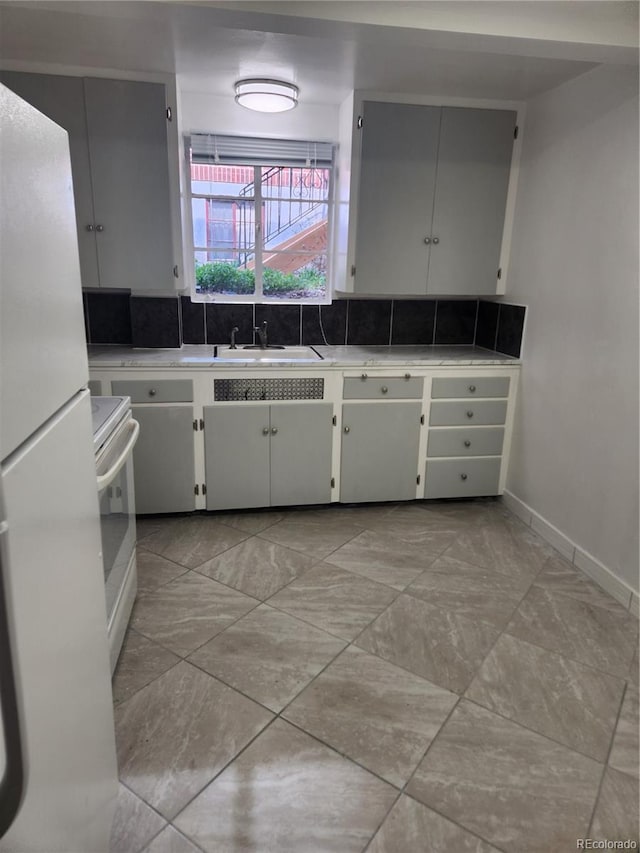 1822 E Pikes Peak Ave, Colorado Springs, CO 80909 - kitchen with white appliances, a sink, light countertops, baseboards, and white cabinets