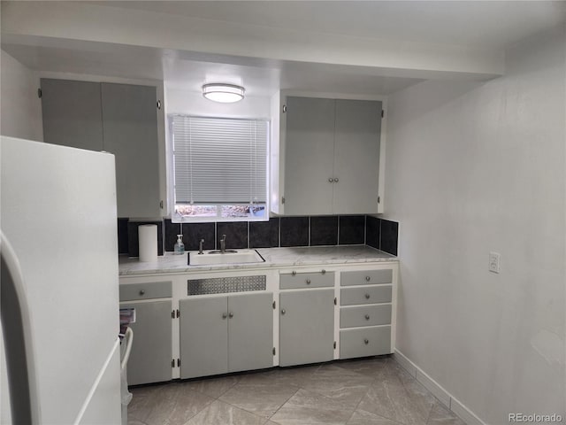 1822 E Pikes Peak Ave, Colorado Springs, CO 80909 - kitchen with freestanding refrigerator, a sink, light countertops, baseboards, and light marble finish floors