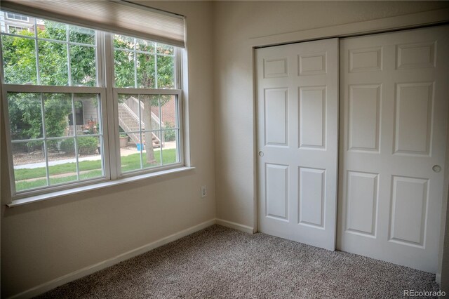 2980 W Centennial Dr Unit L, Littleton, CO 80123 - unfurnished bedroom featuring multiple windows, carpet floors, baseboards, and a closet