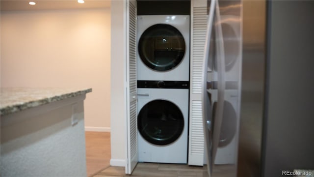 2980 W Centennial Dr Unit L, Littleton, CO 80123 - laundry area featuring stacked washer and clothes dryer, recessed lighting, light wood finished floors, and baseboards