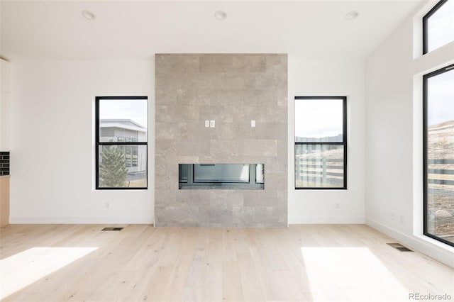 unfurnished living room with a fireplace and light hardwood / wood-style flooring