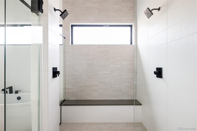 bathroom featuring separate shower and tub and a healthy amount of sunlight