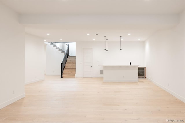 unfurnished living room featuring light hardwood / wood-style floors and wine cooler