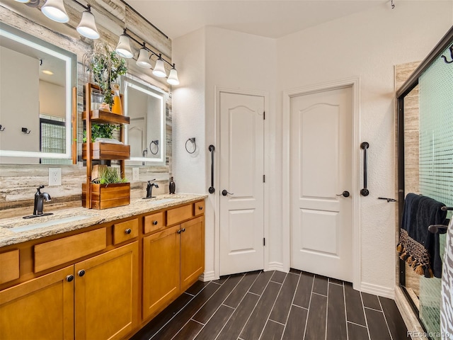 bathroom with hardwood / wood-style floors, vanity, and a shower with shower door