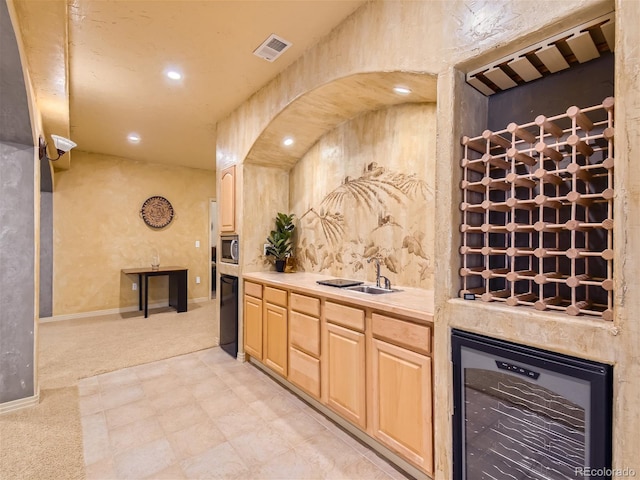 interior space featuring light brown cabinets, light colored carpet, wine cooler, and sink