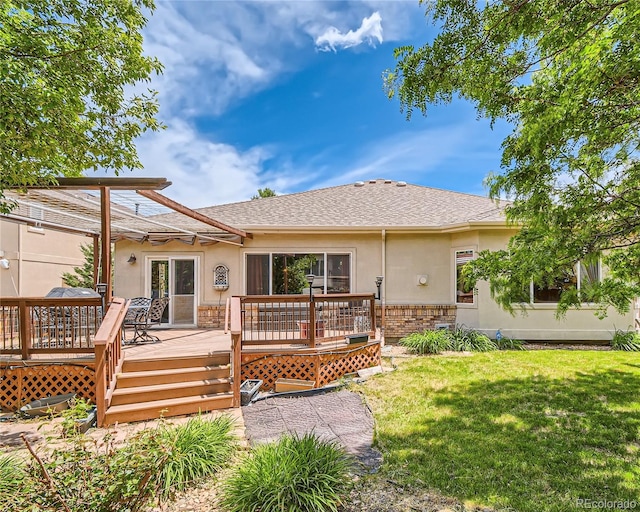 back of property with a yard and a wooden deck