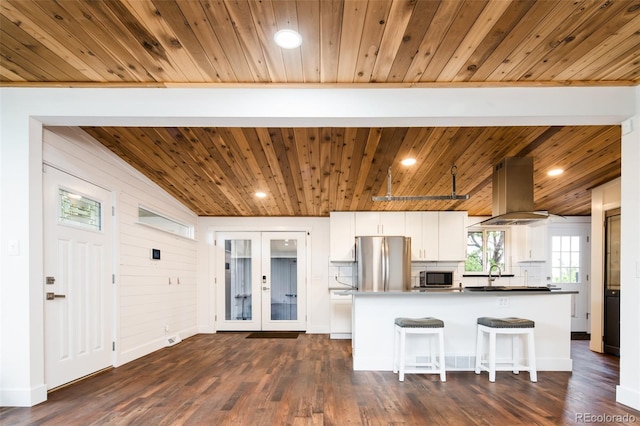 7695 Quitman St, Westminster, CO 80030 - kitchen with wood ceiling, appliances with stainless steel finishes, island range hood, white cabinets, and french doors