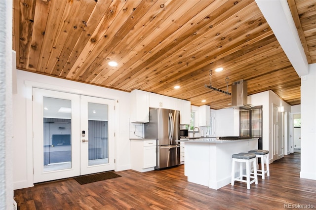 7695 Quitman St, Westminster, CO 80030 - kitchen with freestanding refrigerator, french doors, island range hood, white cabinets, and a breakfast bar