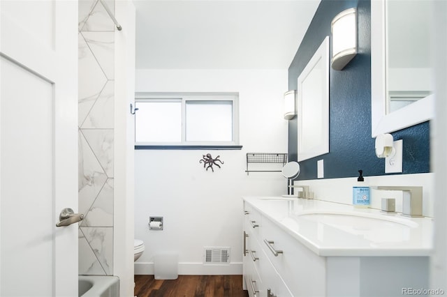 7695 Quitman St, Westminster, CO 80030 - full bathroom with double vanity, toilet, wood finished floors, bathtub / shower combination, and baseboards