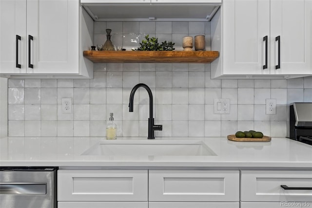 kitchen with tasteful backsplash, sink, and white cabinets