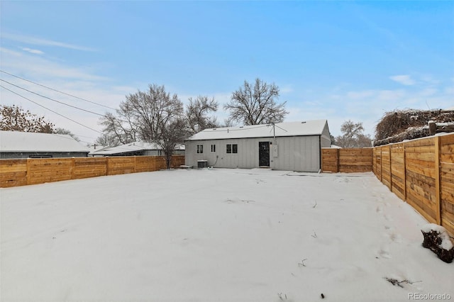 snow covered back of property with an outdoor structure