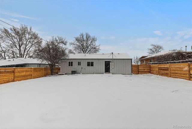 snow covered rear of property featuring cooling unit