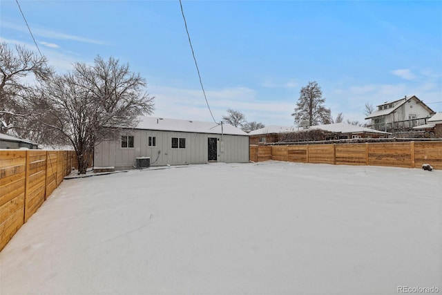 snow covered back of property with central AC