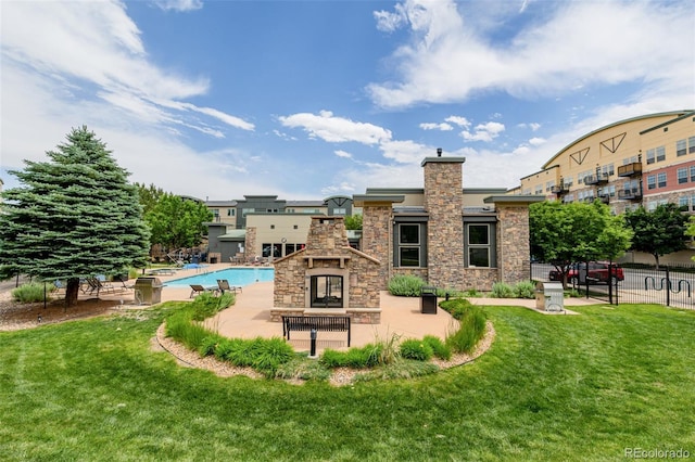 13456 Via Varra Unit 401, Broomfield, CO 80020 - back of house with stone siding, a multi sided fireplace, a patio area, a community pool, and a chimney