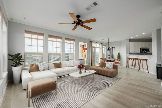13456 Via Varra Unit 401, Broomfield, CO 80020 - living area with light wood finished floors, ceiling fan, recessed lighting, and crown molding