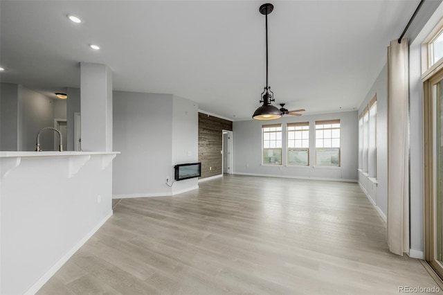 13456 Via Varra Unit 401, Broomfield, CO 80020 - unfurnished living room with ceiling fan, recessed lighting, a multi sided fireplace, and light wood-style floors