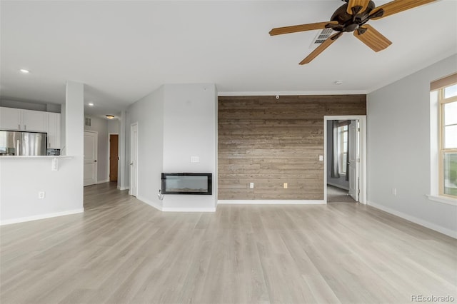 13456 Via Varra Unit 401, Broomfield, CO 80020 - unfurnished living room with wooden walls, a glass covered fireplace, ceiling fan, light wood finished floors, and recessed lighting