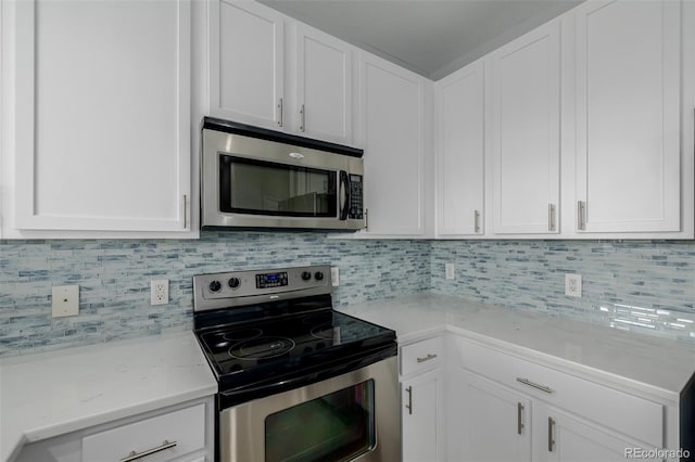 13456 Via Varra Unit 401, Broomfield, CO 80020 - kitchen with appliances with stainless steel finishes, white cabinets, decorative backsplash, and light stone countertops