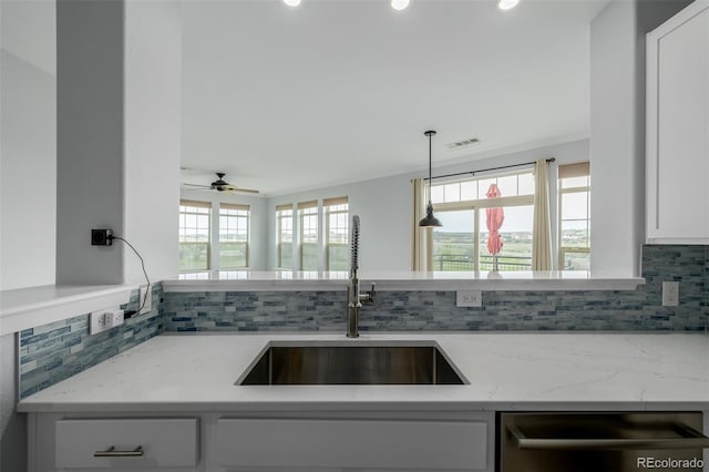 13456 Via Varra Unit 401, Broomfield, CO 80020 - kitchen featuring dishwasher, decorative backsplash, light stone counters, white cabinetry, and recessed lighting