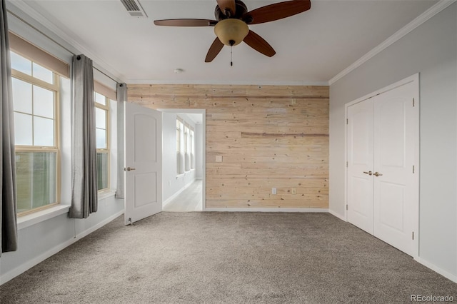 13456 Via Varra Unit 401, Broomfield, CO 80020 - unfurnished bedroom featuring wood walls, ornamental molding, carpet floors, a ceiling fan, and a closet