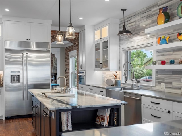 kitchen featuring light stone counters, white cabinets, and stainless steel appliances