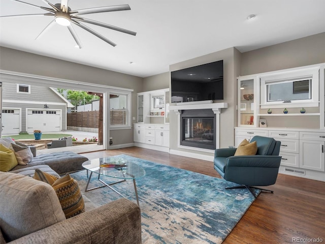 living room with ceiling fan and dark wood-type flooring