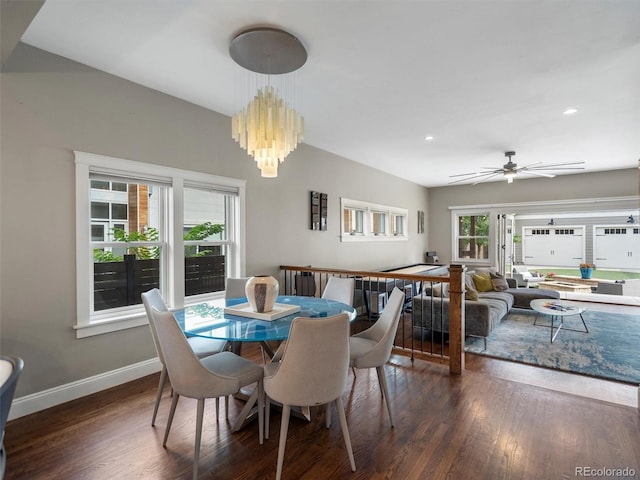 dining area with ceiling fan with notable chandelier and dark hardwood / wood-style floors