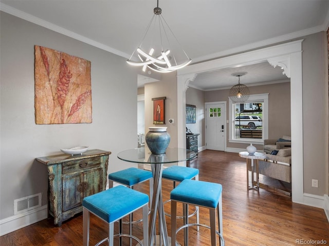 dining space with hardwood / wood-style flooring, a chandelier, and ornamental molding