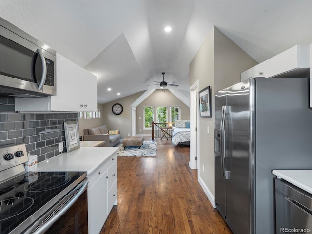 kitchen featuring appliances with stainless steel finishes, white cabinetry, dark hardwood / wood-style flooring, backsplash, and vaulted ceiling