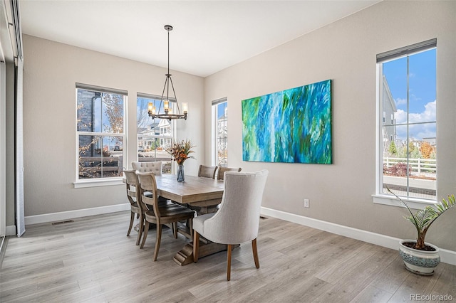 dining space with a wealth of natural light, a chandelier, and light wood-type flooring