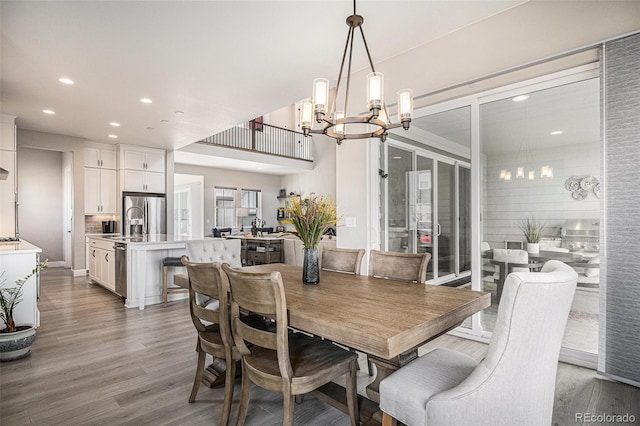 dining area featuring hardwood / wood-style flooring and an inviting chandelier