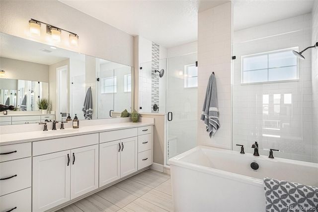 bathroom with vanity, shower with separate bathtub, and a textured ceiling