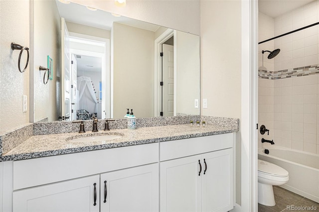 full bathroom featuring tile patterned flooring, vanity, toilet, and tiled shower / bath combo