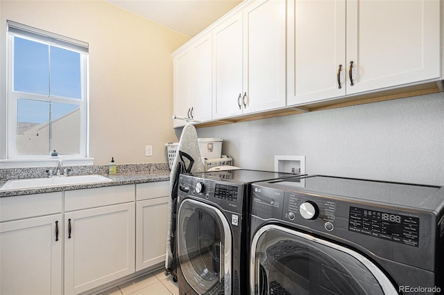 laundry area with cabinets, sink, independent washer and dryer, and light tile patterned floors