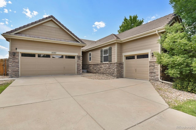 13787 Josephine Ct, Thornton, CO 80602 - view of front of property with an attached garage, driveway, stone siding, and a tile roof