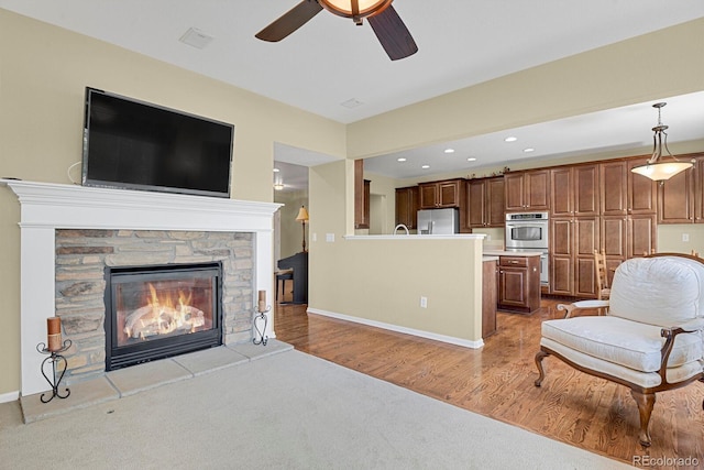 13787 Josephine Ct, Thornton, CO 80602 - living area with a stone fireplace, light colored carpet, a ceiling fan, and recessed lighting