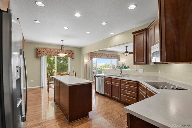 13787 Josephine Ct, Thornton, CO 80602 - kitchen featuring stainless steel appliances, a kitchen island, light wood-style flooring, recessed lighting, and a textured ceiling