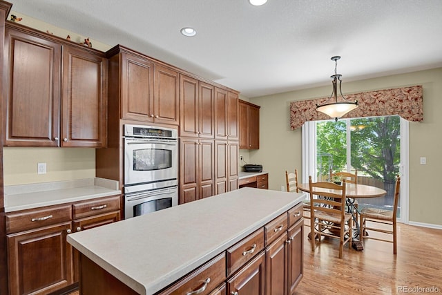 13787 Josephine Ct, Thornton, CO 80602 - kitchen with double oven, light countertops, hanging light fixtures, light wood-type flooring, and recessed lighting
