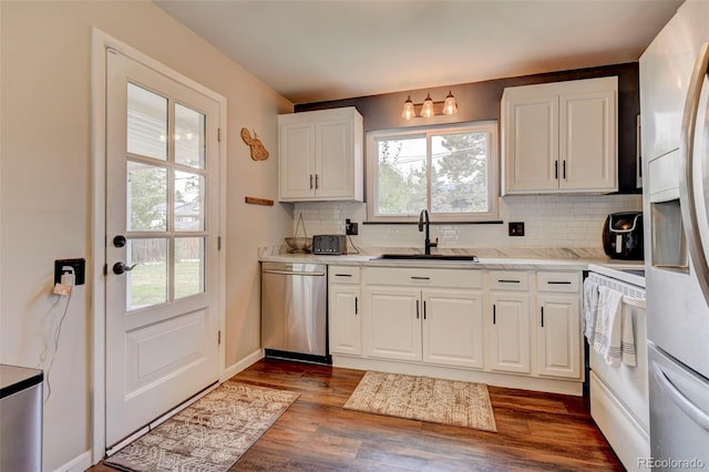 kitchen featuring white electric range, tasteful backsplash, dishwasher, sink, and white cabinets