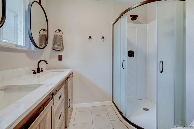 bathroom with an enclosed shower, vanity, and tile patterned floors