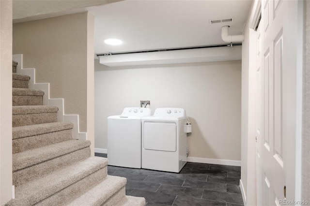 laundry area featuring dark tile patterned floors and washer and clothes dryer